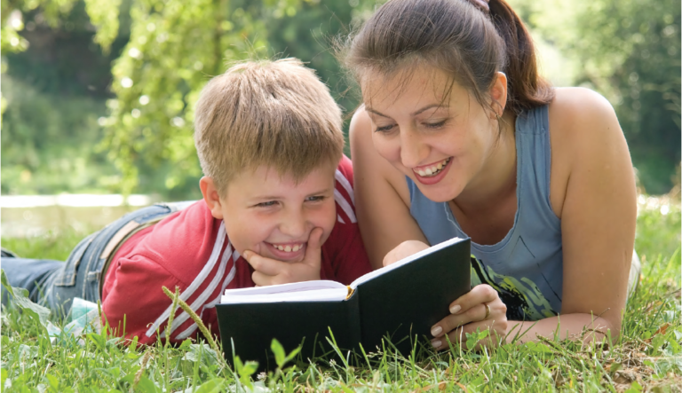 Woman reads to boy in a park